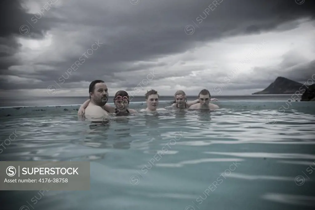 Portrait of five people swimming in an infinity pool, Iceland