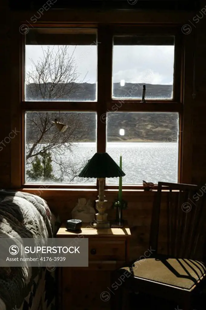 Bedroom window facing a hill and a lake
