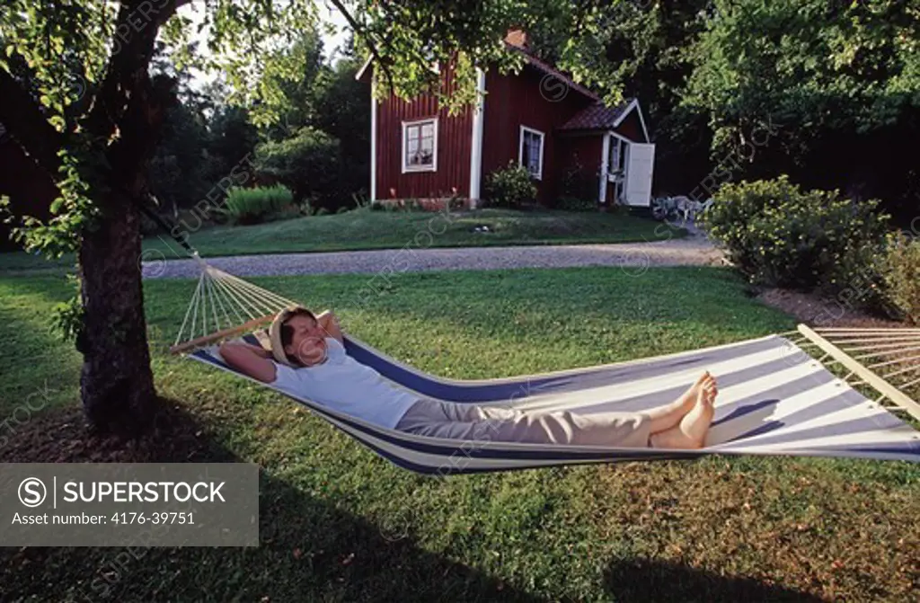 Women taking a nap in a hammock infront of the summerhouse