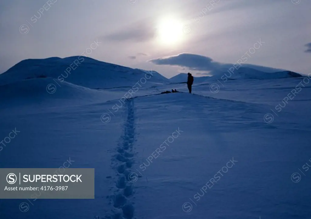 Silhouette of a man in snowy mountains of Lappland