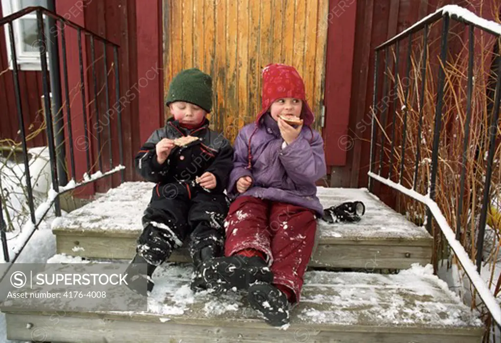 Children sitting on a porch and eating. Sweden