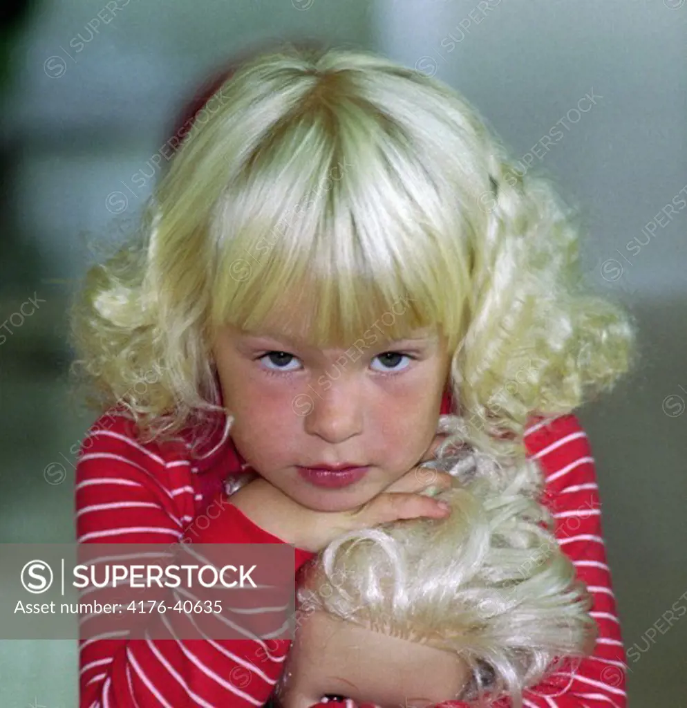 A blond girl holding a blond doll - Blond flicka med blond docka