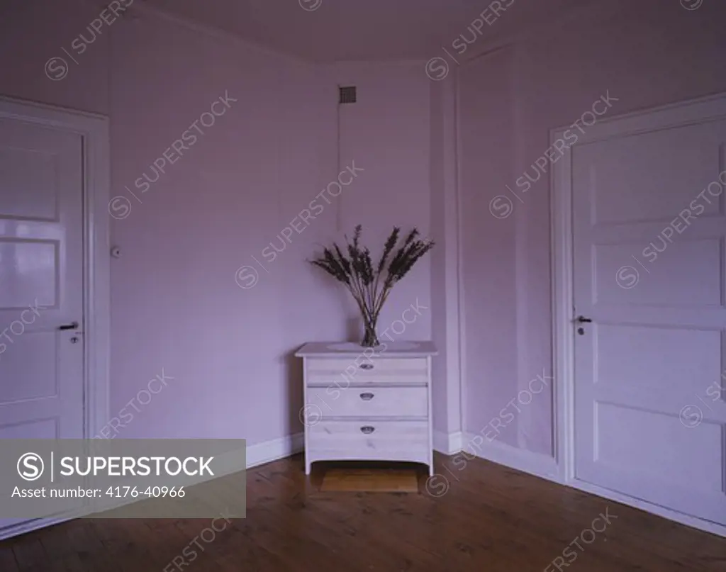 A corner of a room with pink walls