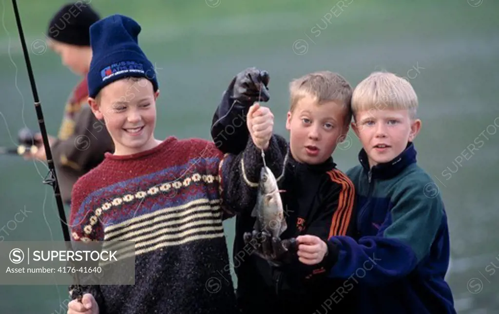 Three young boys with a fishing pole