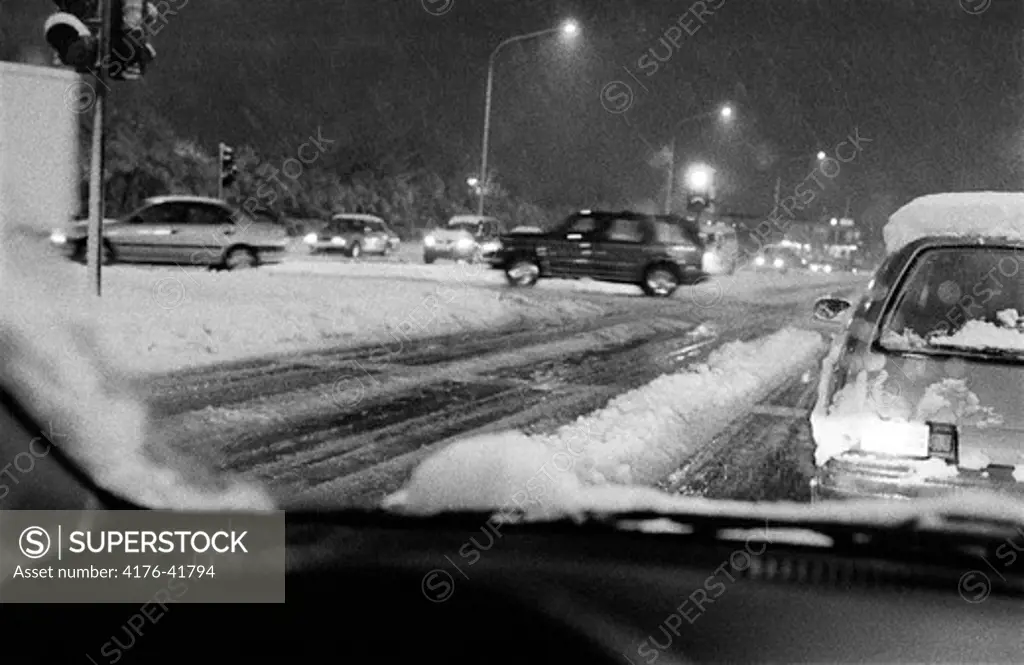 Cars driving on a snowy street at night, Reykjavik, Iceland