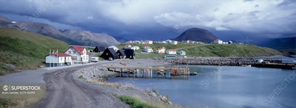 The village Hofsós, north Iceland, mountains in background and cloudy sky above