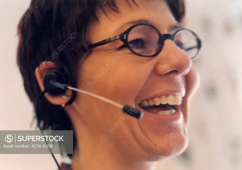 Close-up of a customer service representative wearing a headset and laughing