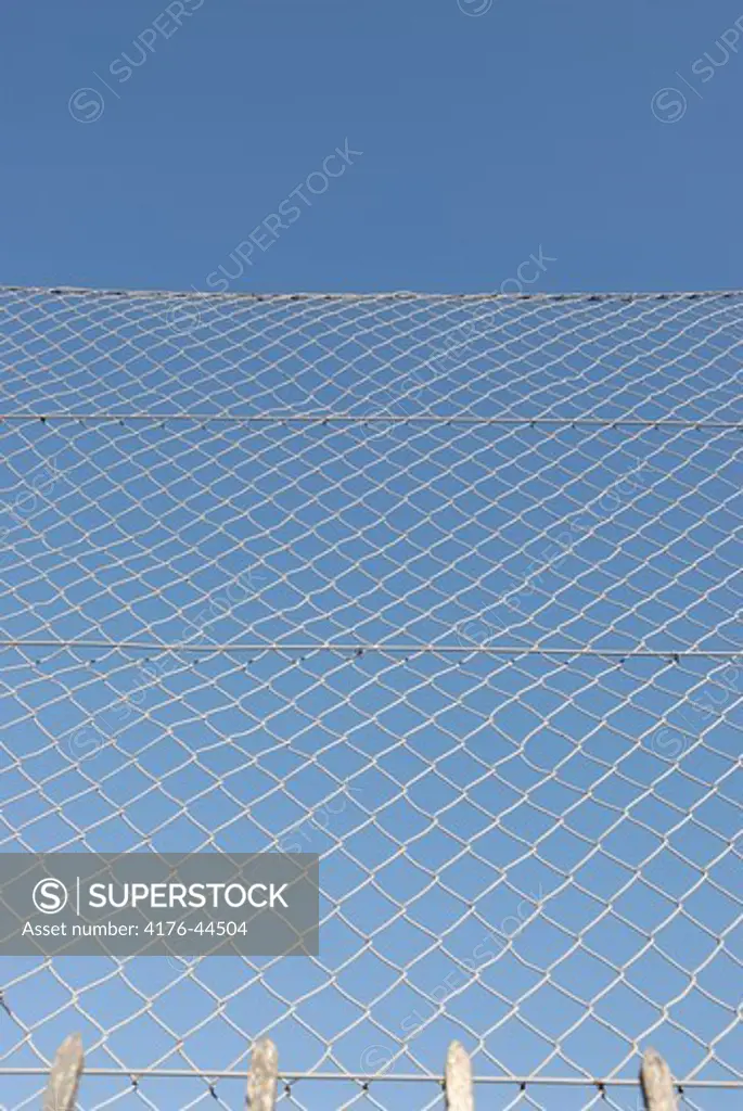 Fence in front of a blue sky.