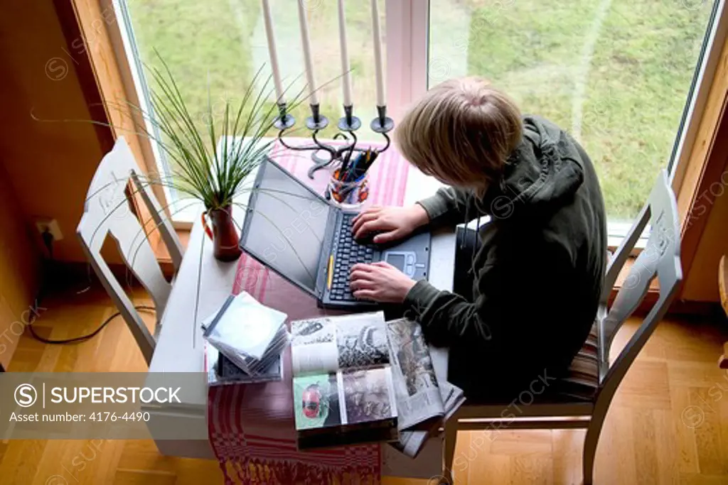 High angle view of a boy working on a laptop