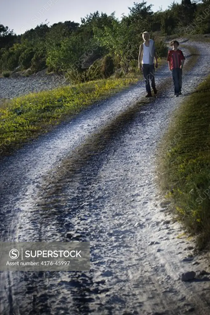 Two people walking on a dirt road