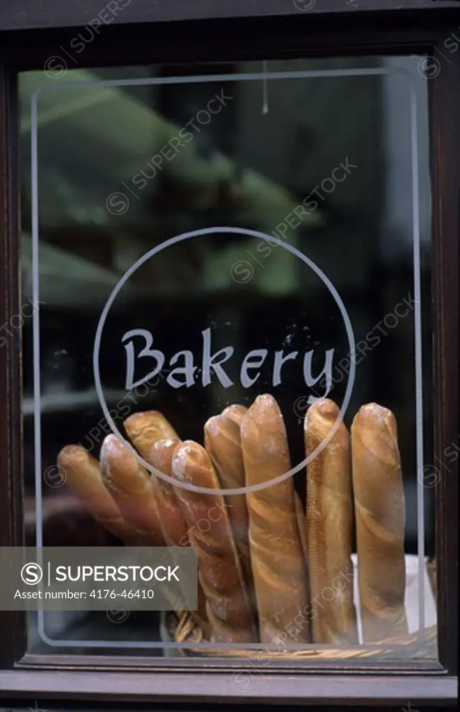a lot of baguettes in a cage in a bakery