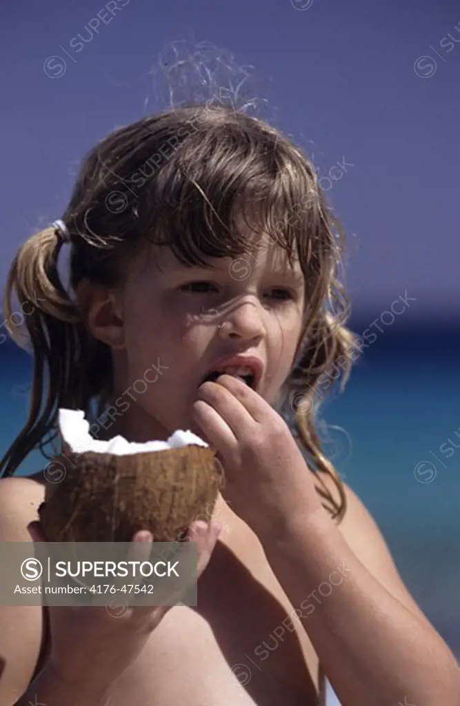 Flicka äter kokos