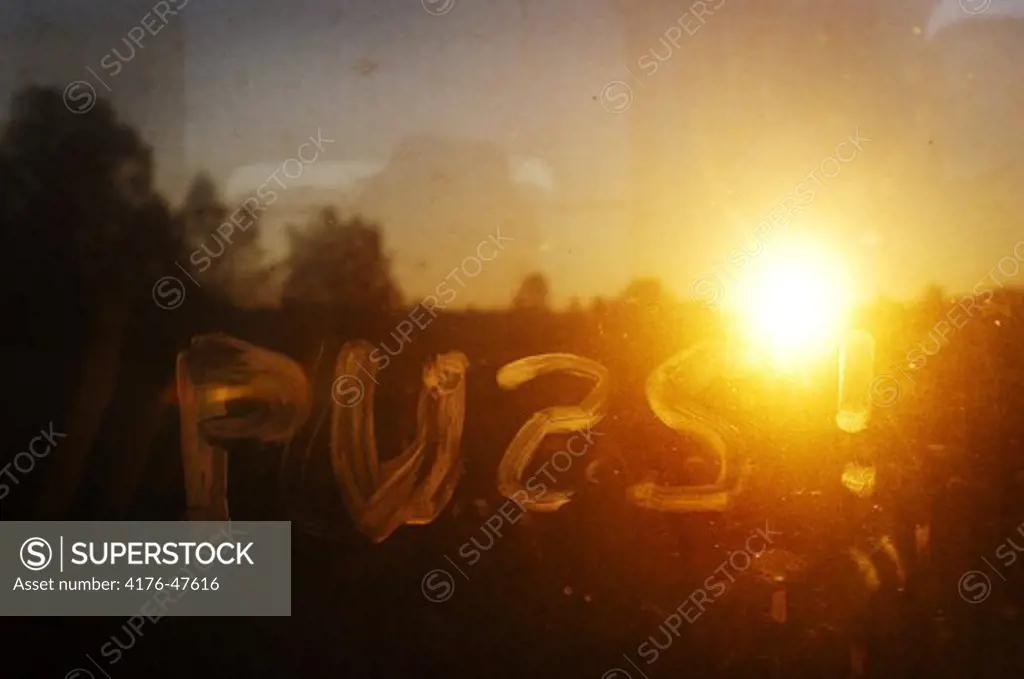 The Swedish word for kiss written on train window, in sunset