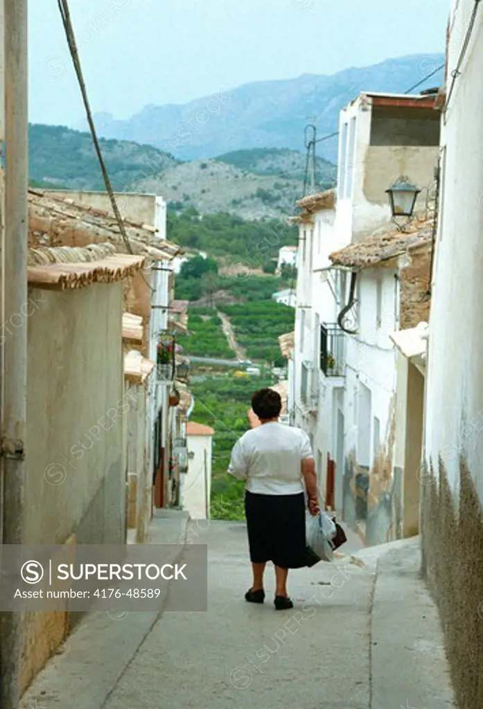 Woman in an alley in a village in Alicanteregion. Spain.