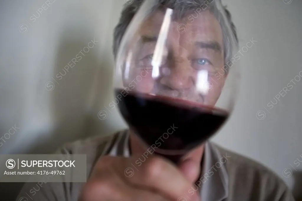 En man skålar i rödvin.