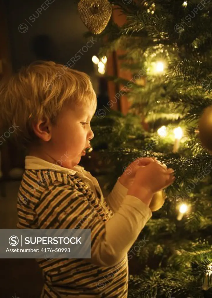 Little boy hanging up Christmasdecorations