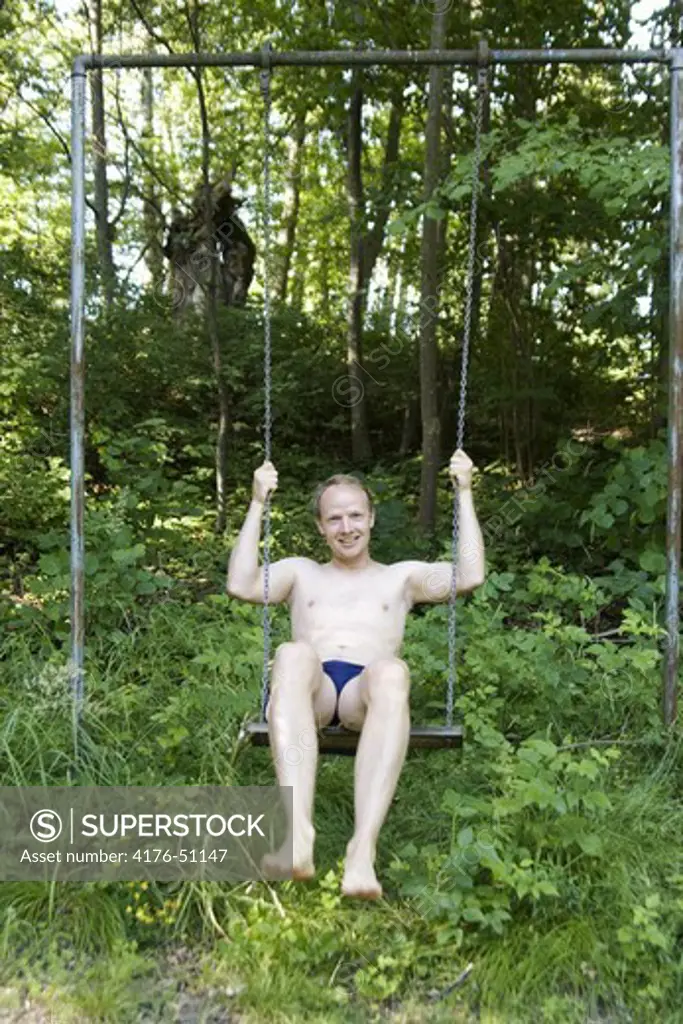 Man sitting in a childrens swing.