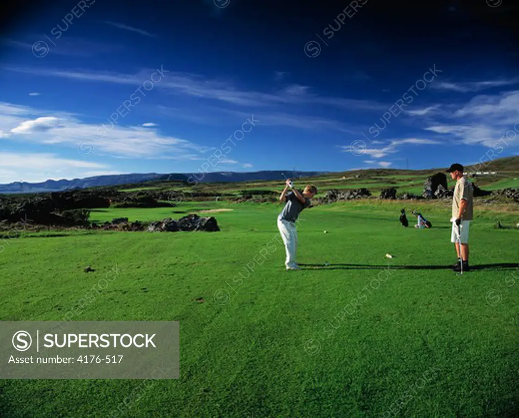 Two men playing golf in a golf course, Iceland
