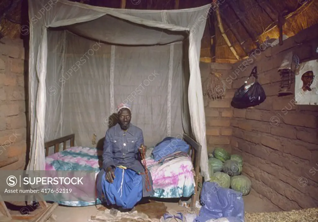 Afrika, Senegal Imamen Ibrahima  sitter på sängkanten i sitt hus