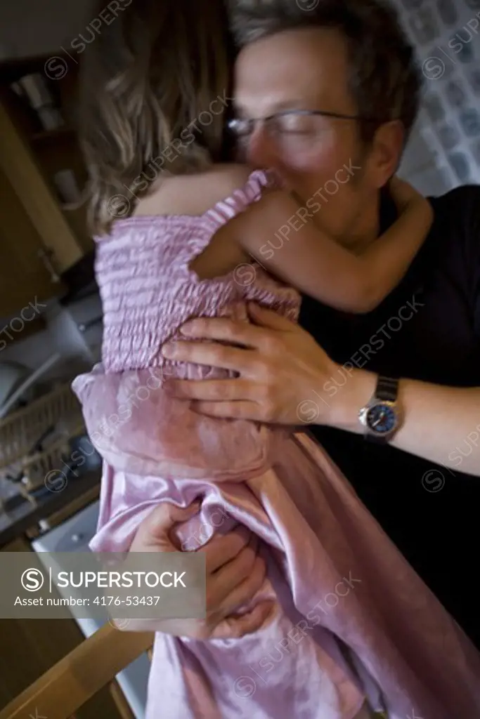 En pappa kramar sin dotter.