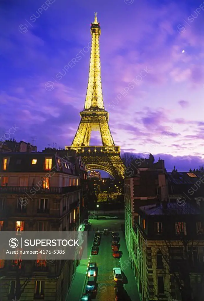 Apartment buildings and street leading to Eiffel Tower at twilight