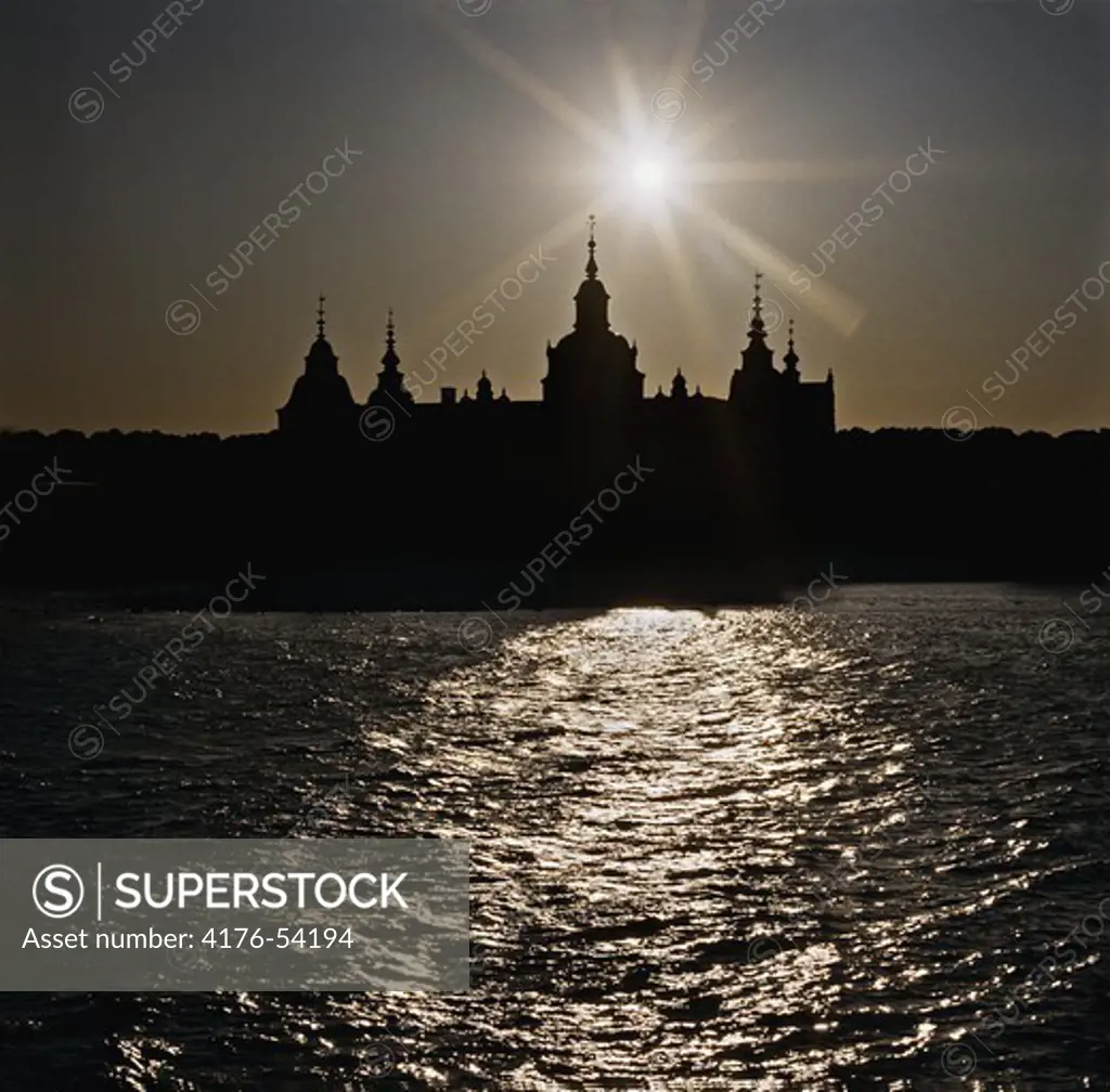 Silhuett av Kalmar Slott med solnedgång och gnistrande vatten