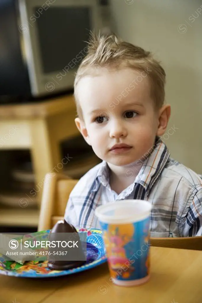 Boy looking seriously at birthday-party.