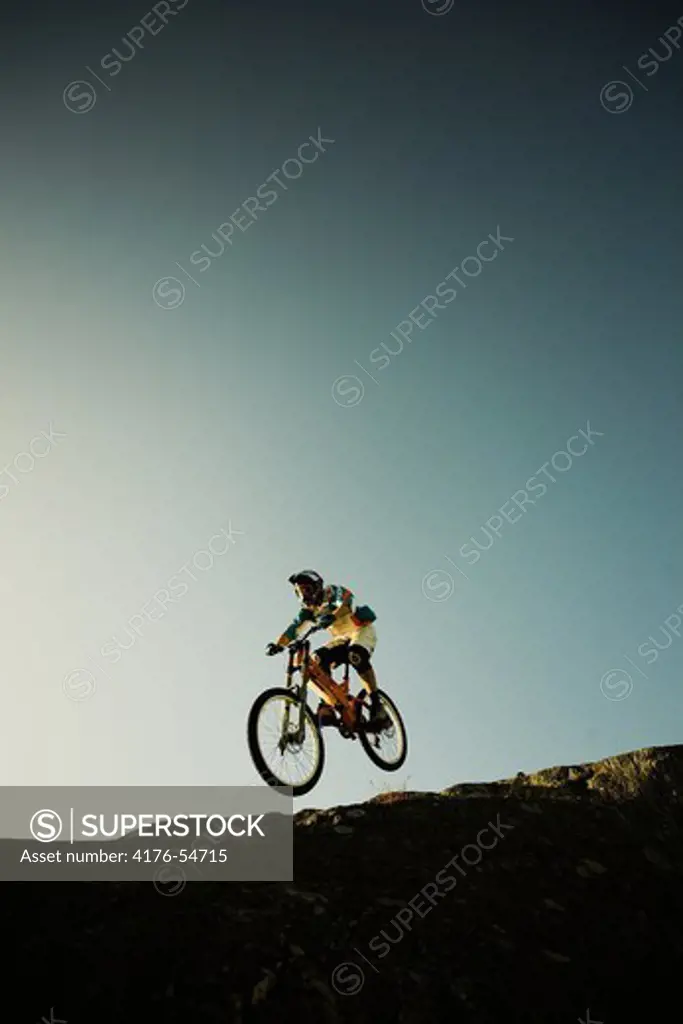 A man on a mountainbike going down a steep cliff, Sweden.