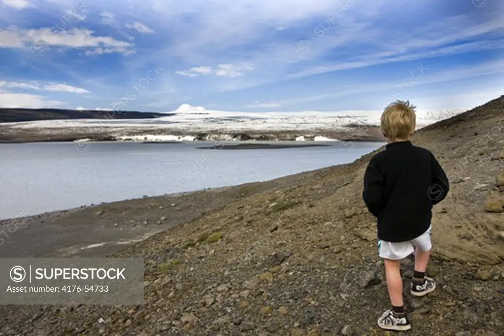 A boy standing near seashore. Iceland