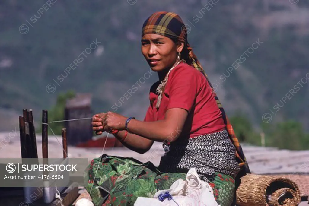 Woman from Ghandruk village of Nepal preparing yarn