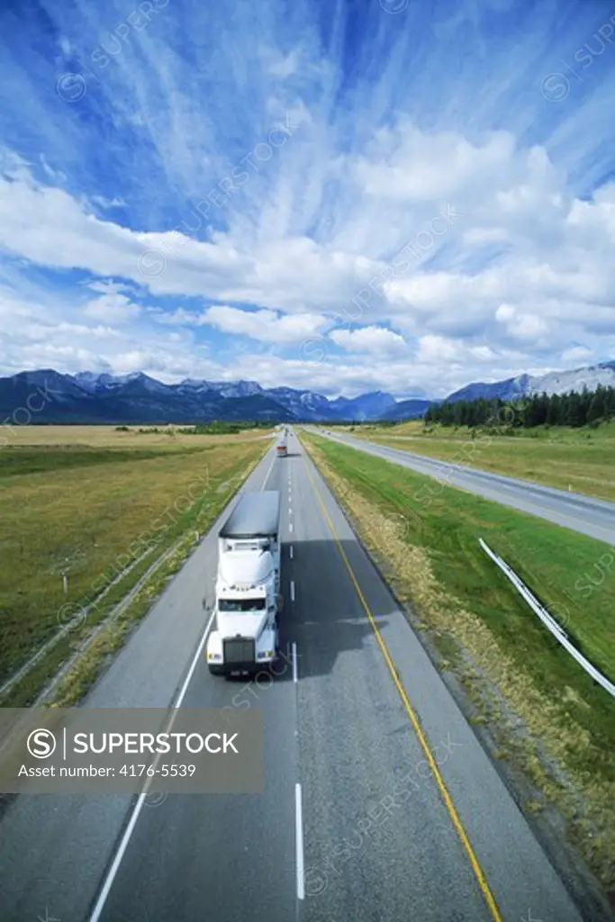 Truck flying like the clouds down Canadian highway in Alberta