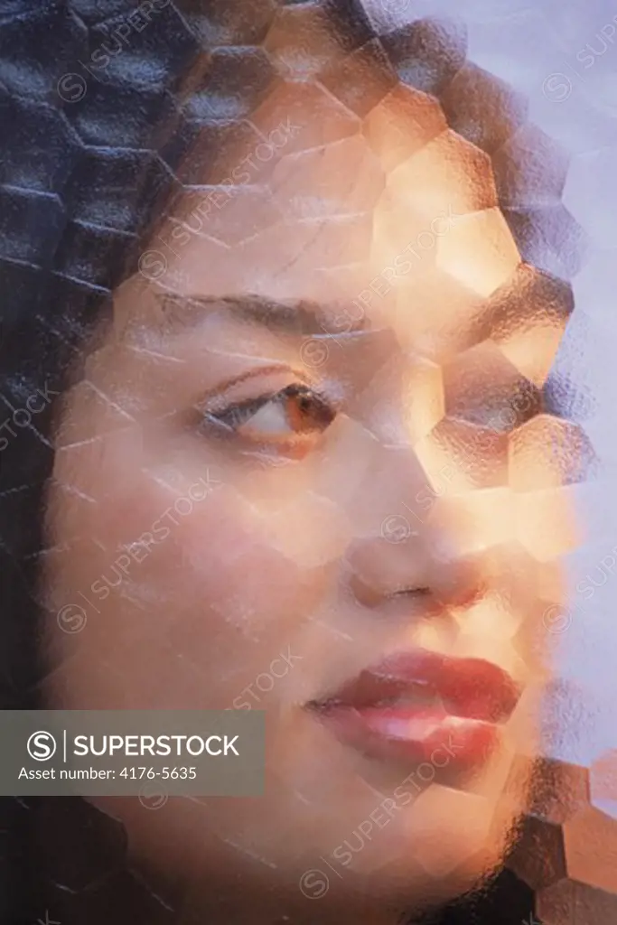 Woman of Spanish Italian Filipino Korean mix looking through mosaic glass