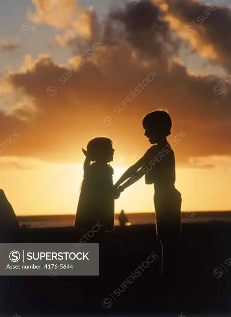 Boy and girl holding eachother at sunset