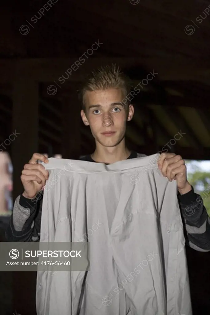 Young man holding cotton shirt