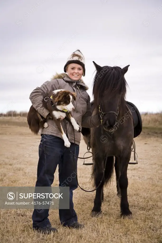 Young woman with her horse and dog.  South Iceland.