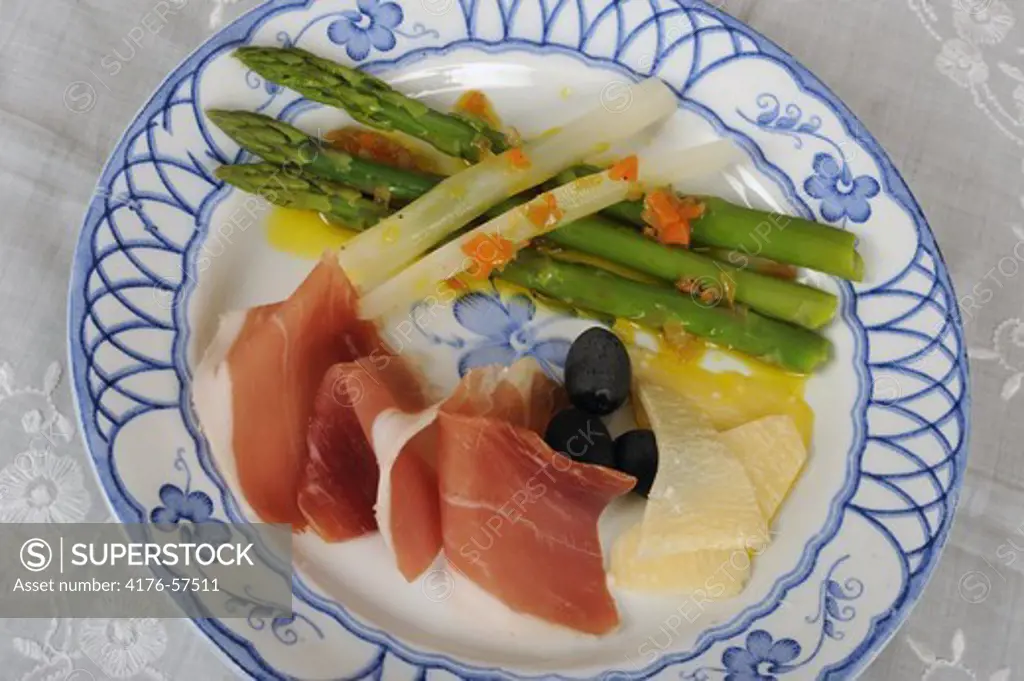 First course with ham, asparagus, olives and cheese
