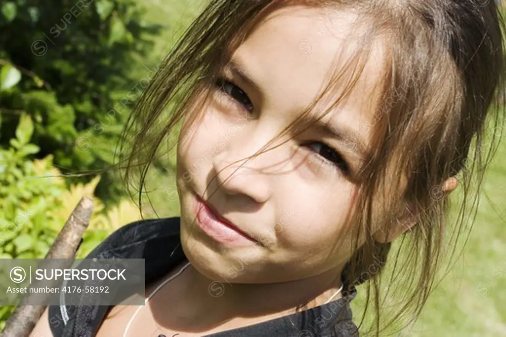 Young girl with a long fringe smiling at camera.