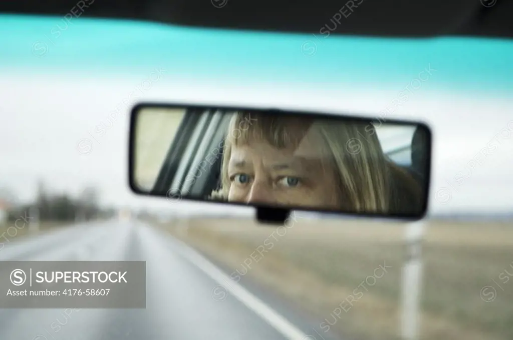 Woman looking in rear-view morror