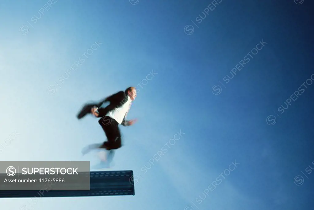 Businessman about to run off diving board