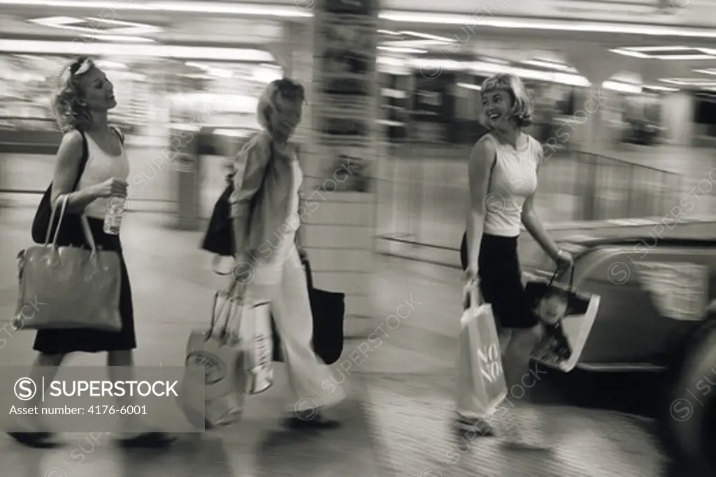 Three women with shopping bags at metro station in Stockholm
