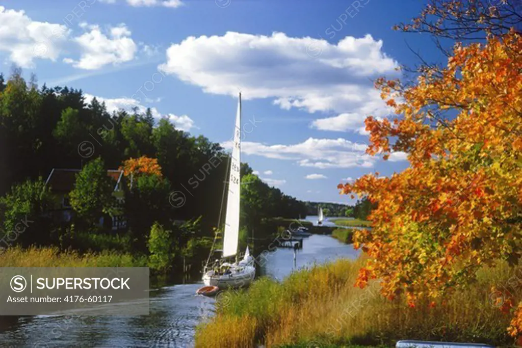 Sailboat on canal passing through Stockholm Archipelago and its 25,000 islands in autumn