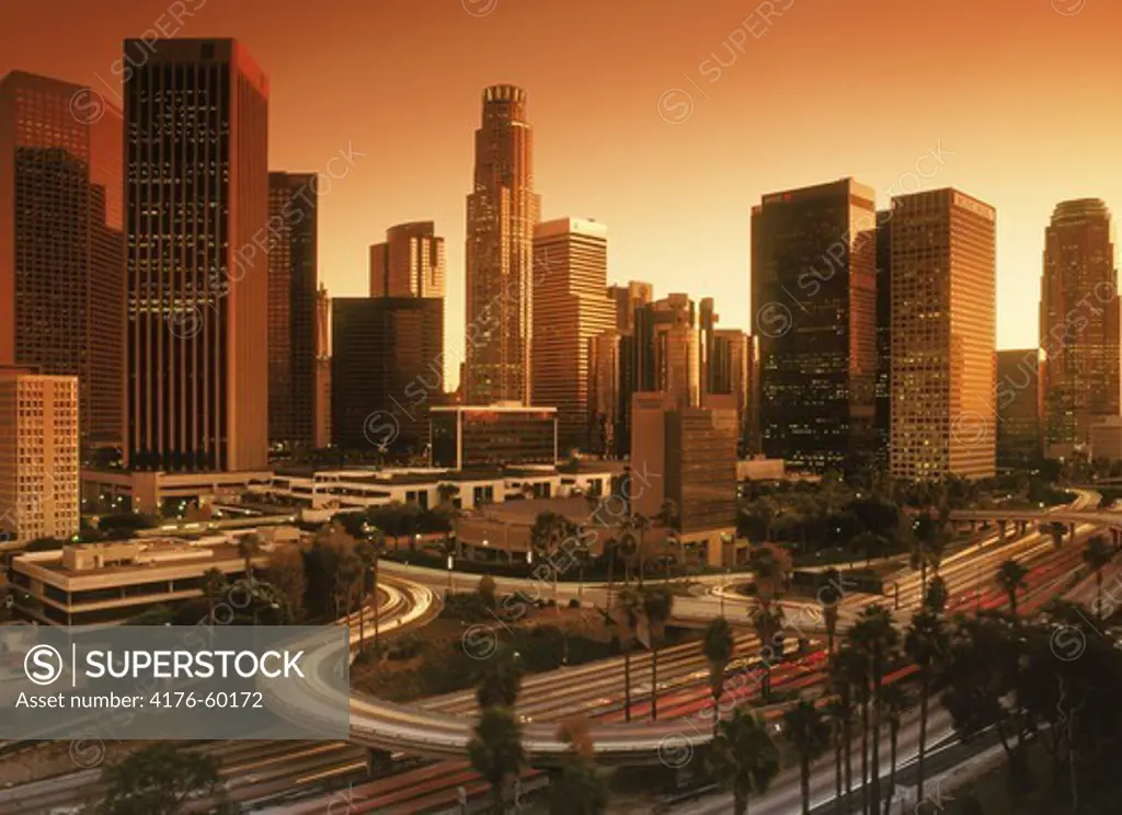 Downtown Los Angeles with rush hour traffic passing on roads and freeways at dusk