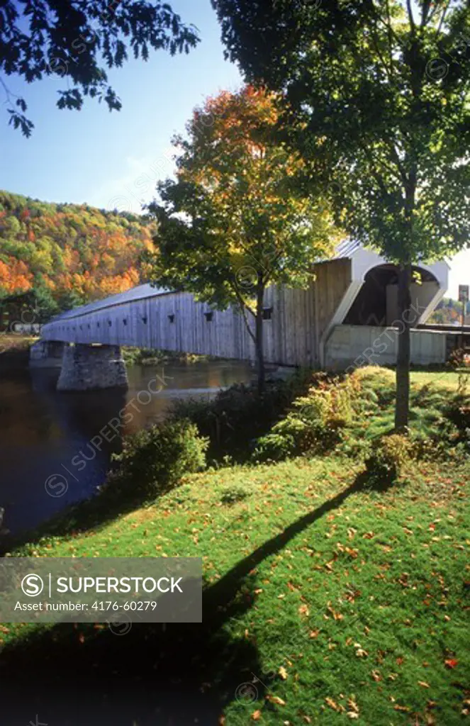 New England Cornish bridge over Connecticut River at Windsor, New Hampshire amid autumn colors