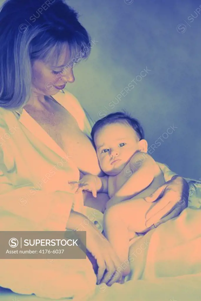 Baby resting in mothers arms after breast feeding