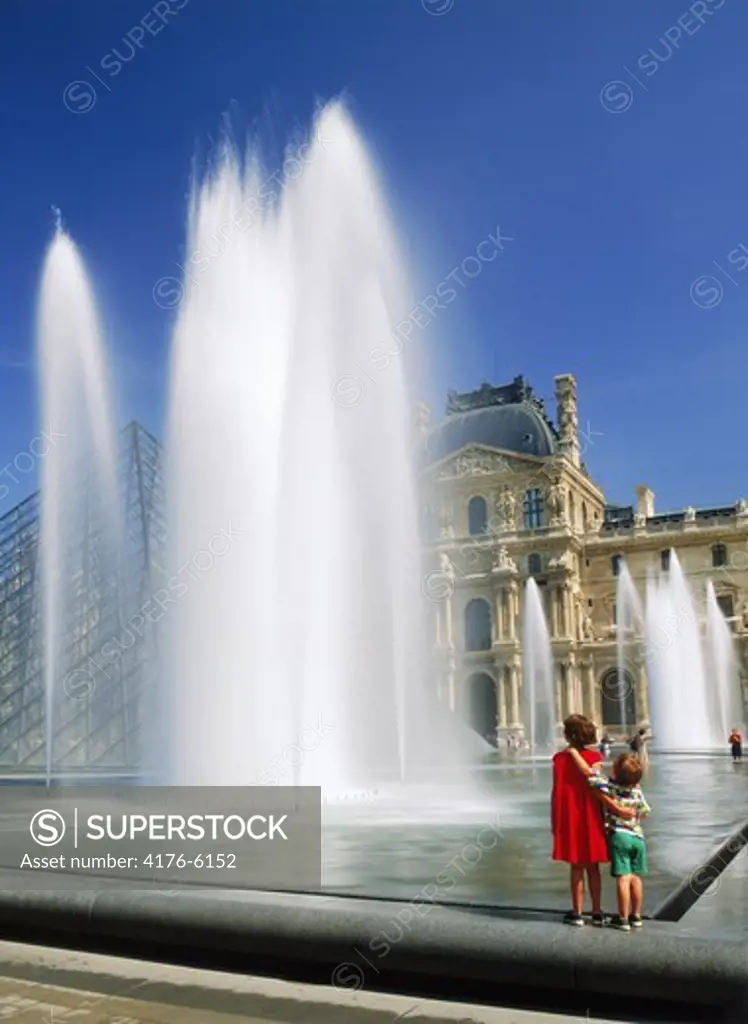 Children next to fountains at Louvre Palace Museum in Paris