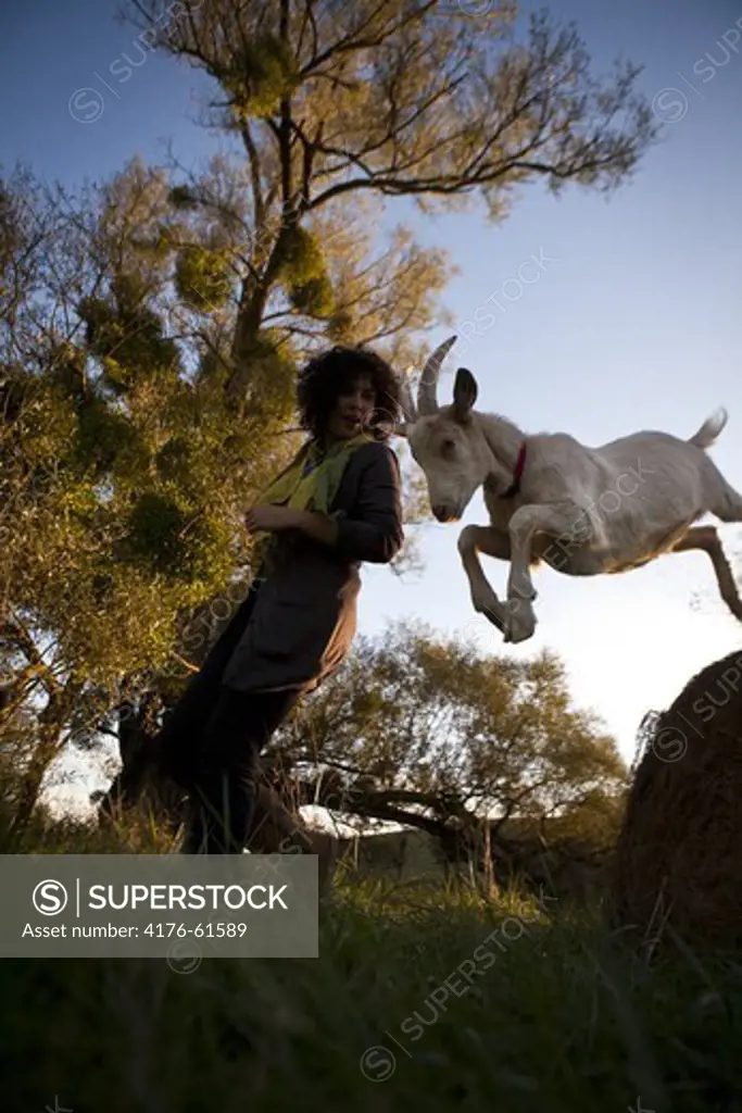 Woman with jumping goat, Toulouse, France,