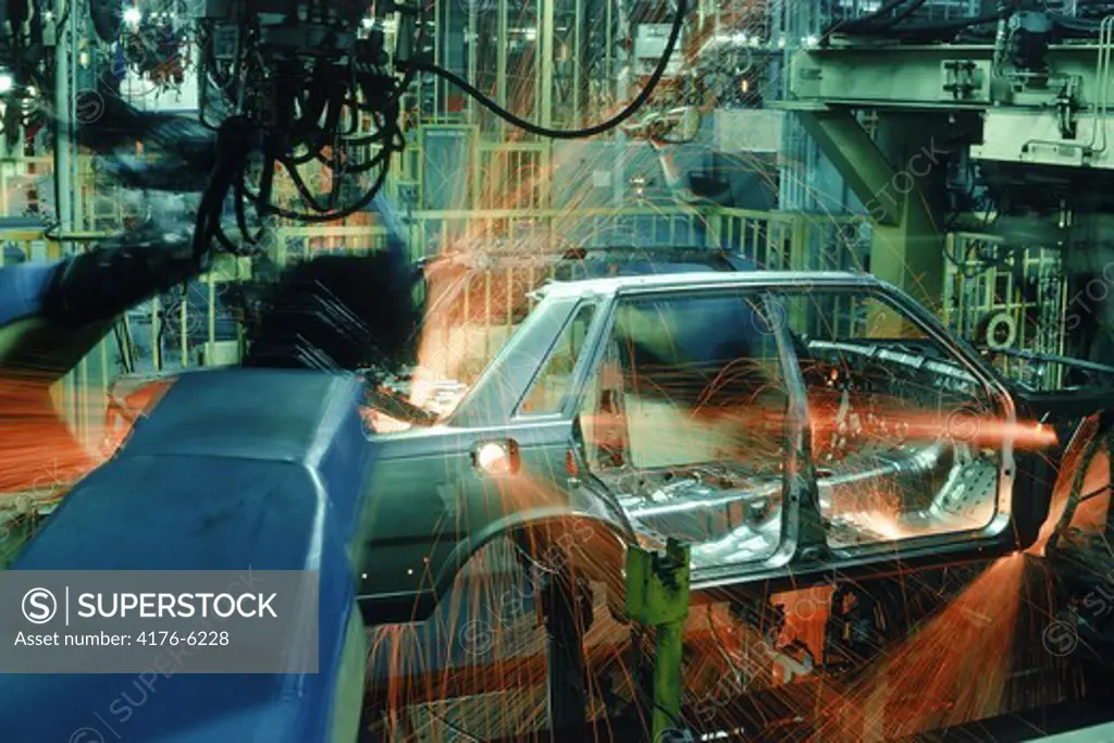 Sparks flying from spot welding robotics at automobile factory
