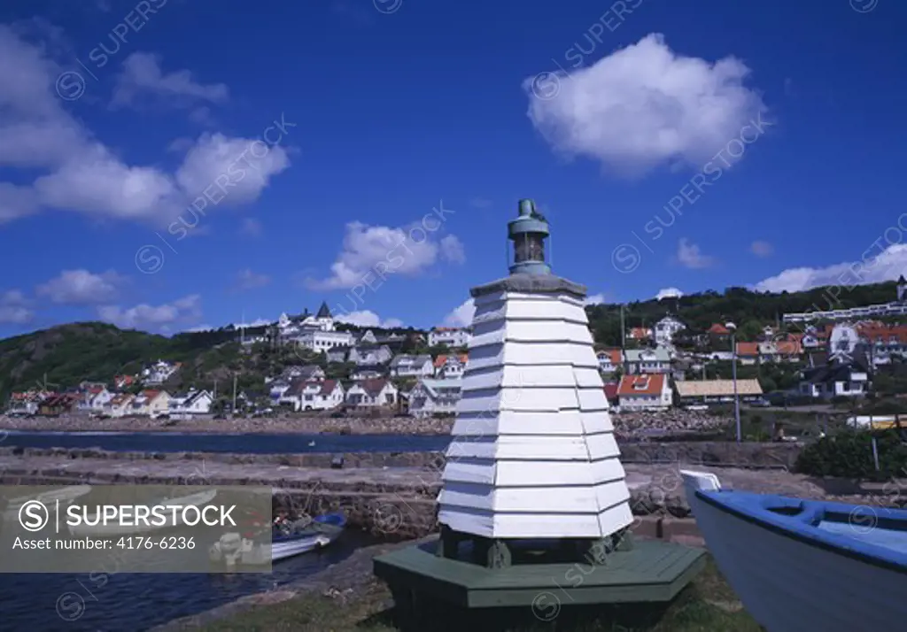 Lighthouse with moored boats and houses