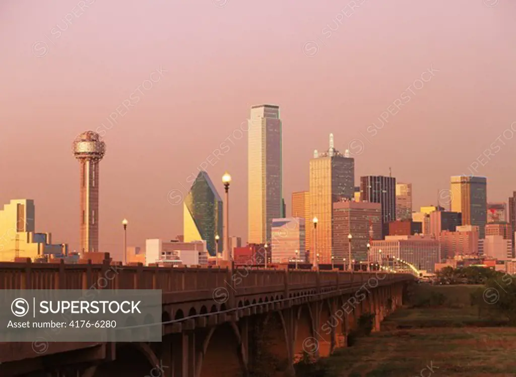 Dallas skyline in sunset light over viaduct with Reunion Tower on left