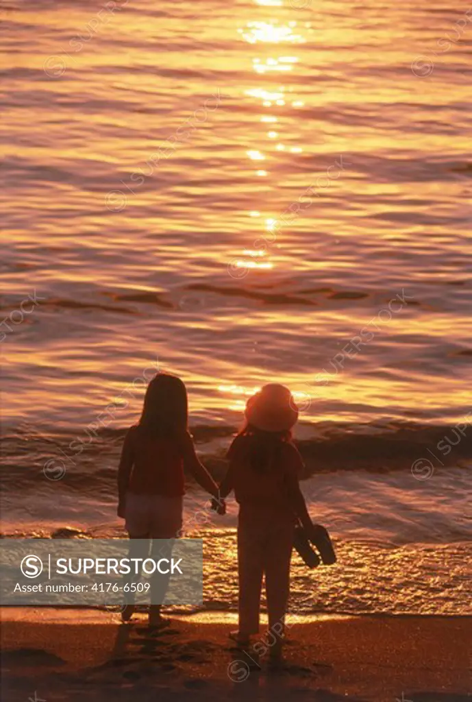 Two girls on beach in sunset light
